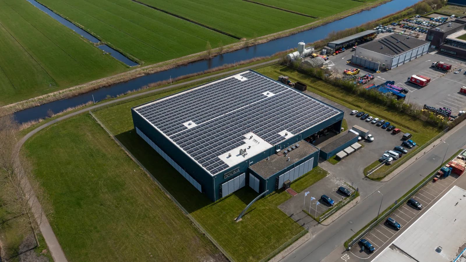 Luchtfoto van het Douna-bedrijfspand met het dak vol zonnepanelen